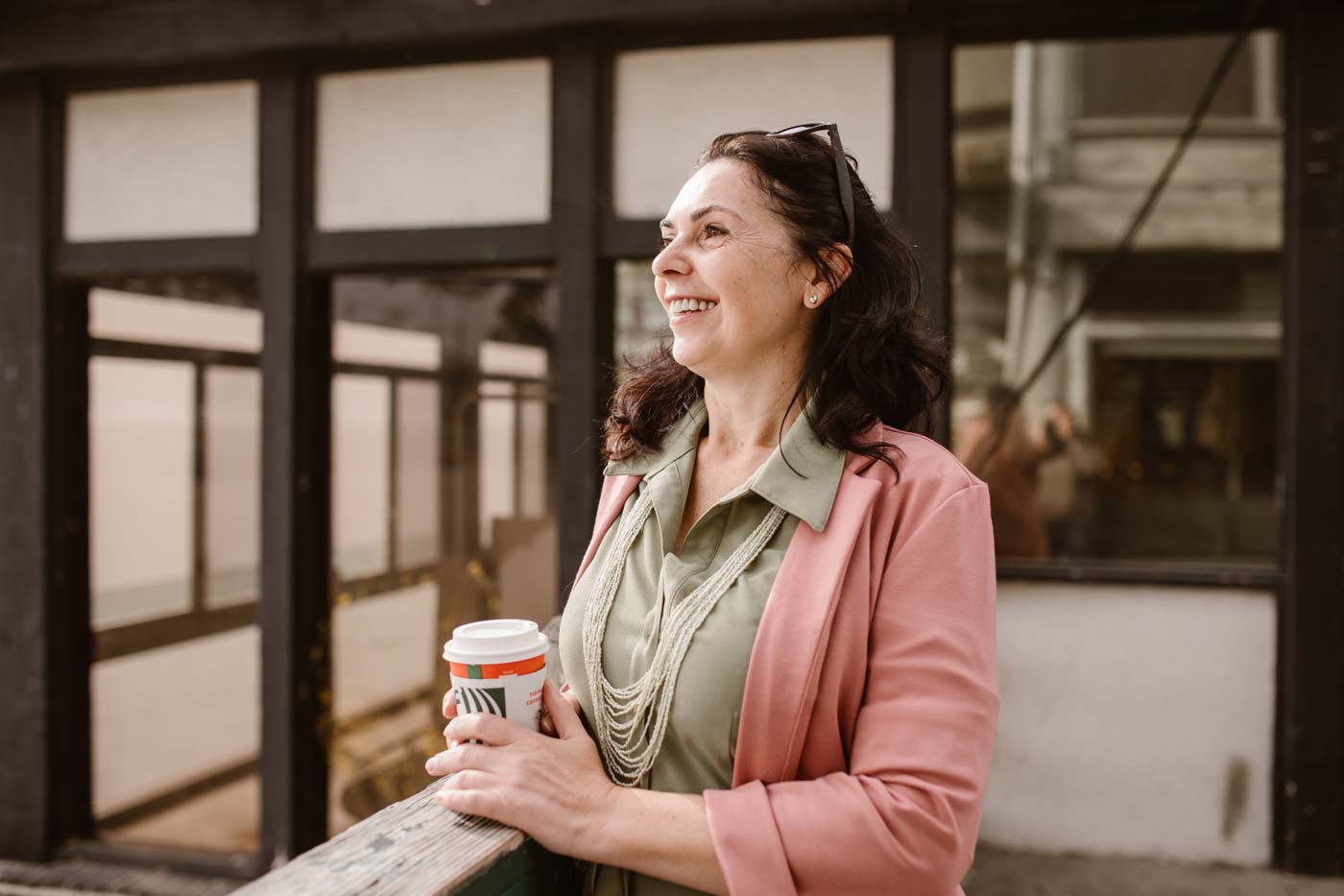 middle-aged woman with cup of coffee smiling